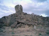 a man standing on top of a large rock formation